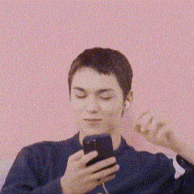 a man is listening to music on his phone while wearing ear buds .