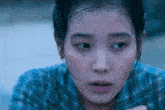 a close up of a woman 's face in a blue shirt