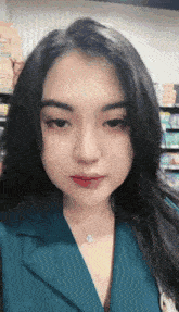 a woman with long black hair is wearing a blue jacket