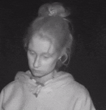a black and white photo of a woman with a bun on her head .