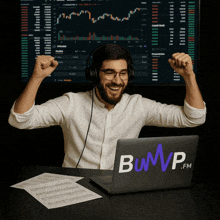 a man wearing headphones is sitting at a desk with a laptop that says bump.fm