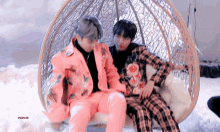 two men in suits are sitting in a wicker chair with the letters psr on the bottom
