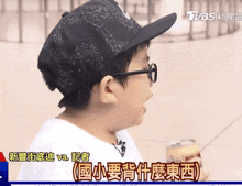 a boy wearing a hat and glasses is eating a can of soda