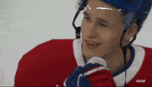 a hockey player wearing a red white and blue jersey with ads written on it