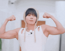 a man wearing a knitted hat and a white tank top says " oli "