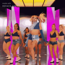 a group of women are dancing in a room with a man in a crop top