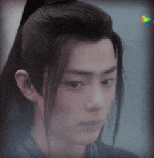 a close up of a person 's face with a ponytail on