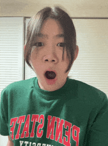 a girl wearing a green shirt that says " state "
