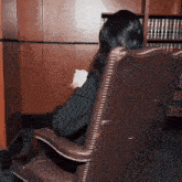 a woman is sitting in a chair in front of a bookshelf