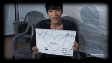 a young man holds up a note that says hottest