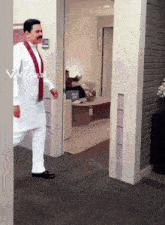 a man in a white shirt and red scarf walks through a doorway with a viggle.ai watermark on the bottom