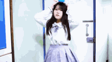 a girl in a white shirt and purple skirt is standing in front of a white door