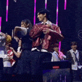 a group of people are dancing on a stage in front of a heart .