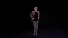 a man is dancing on a stage in a dark room .