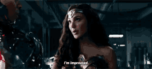 wonder woman is talking to a man in a dark room .