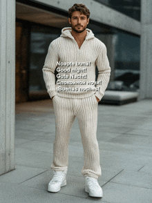 a man wearing a white sweater and pants is standing in front of a building