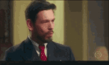 a man in a suit and tie is shown on a television screen