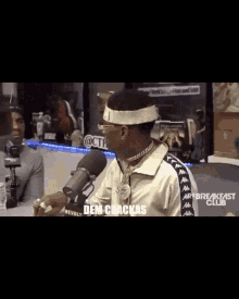 a man talking into a microphone with the words " dem crackas " on the bottom right