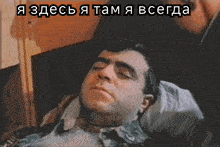 a man is laying in a bed with a caption that says " я здесь я там я всегда " above him