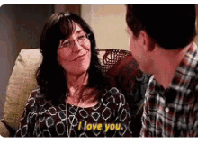 a man and woman are sitting on a couch and the woman says i love you