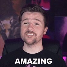 a man with a beard is wearing a black shirt that says " amazing "