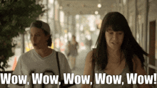 two women walking down a street with the words wow wow wow wow wow written on the bottom