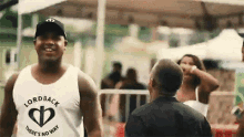 a man wearing a white tank top that says lordback