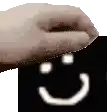 a hand is putting a smiley face on a black background