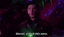 doctor strange is standing in a dark room with a green light in his hand .