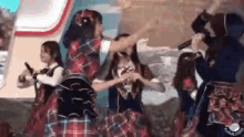a group of young women are dancing on a stage while holding microphones .
