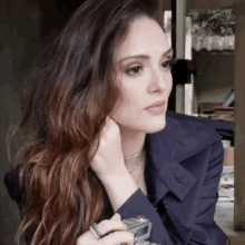 a woman in a trench coat is holding a camera in her hand