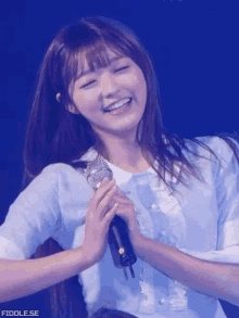 a young girl is holding a microphone and smiling .