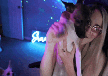a woman is holding a cat in front of a sign that says jay