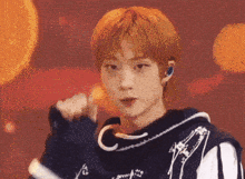a young man with red hair is wearing a black and white striped shirt and a black hoodie .