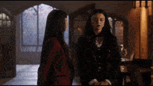 two women standing next to each other in a room