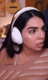 a woman wearing headphones is sitting on a bed .