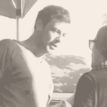 a man and woman are standing under an umbrella and talking to each other