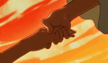 a man and woman are holding hands in front of an orange sky .