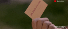 a person holding a card that says apa boleh jual jual on it