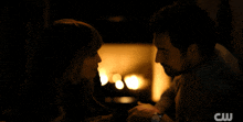 a man and woman are looking into each other 's eyes with a cw logo in the background