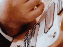 a man is playing a guitar with his mouth open .
