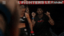 a man and a woman are standing in a cage under a banner that says all fighters league