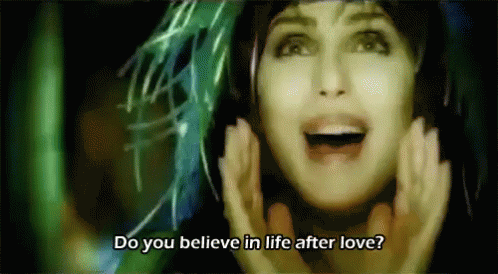 GIF, Cher, singing, feathered hat, captioned "Do you believe in life after love?"