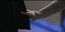a close up of a person 's hand holding a piece of cloth