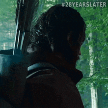 a man is holding a bow and arrow in a forest .