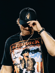 a man wearing a black shirt with the word kid rock on it