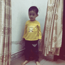 a young boy wearing a yellow shirt that says ' emporio armani ' on the front