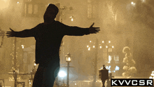 a silhouette of a man with his arms outstretched in front of a sign that says kvvcsr