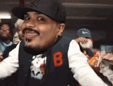 a man with a beard wearing a ny hat and a vest with the number 8 on it