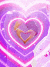 a person making a heart shape with their hands in front of a purple heart